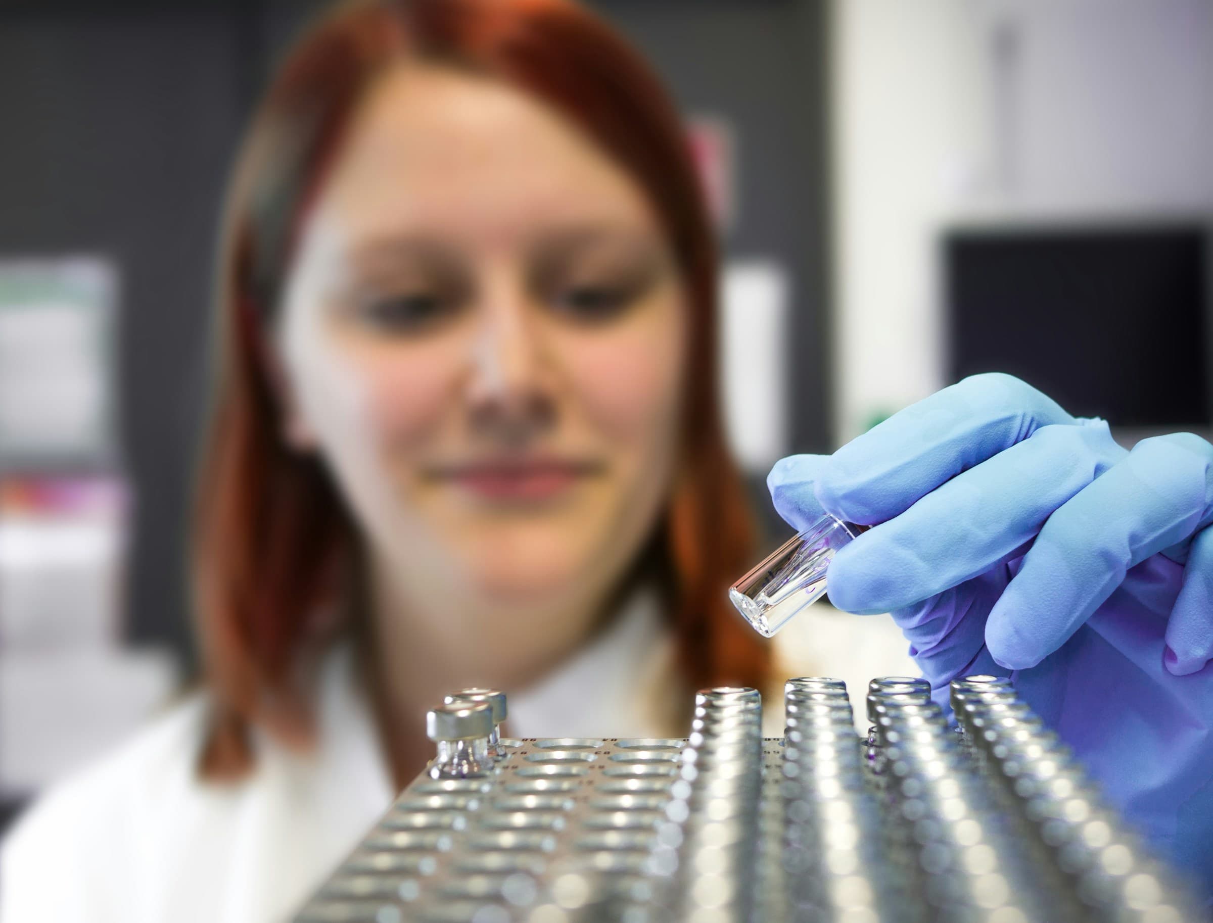 A scientist handling samples with gloved hands in a laboratory